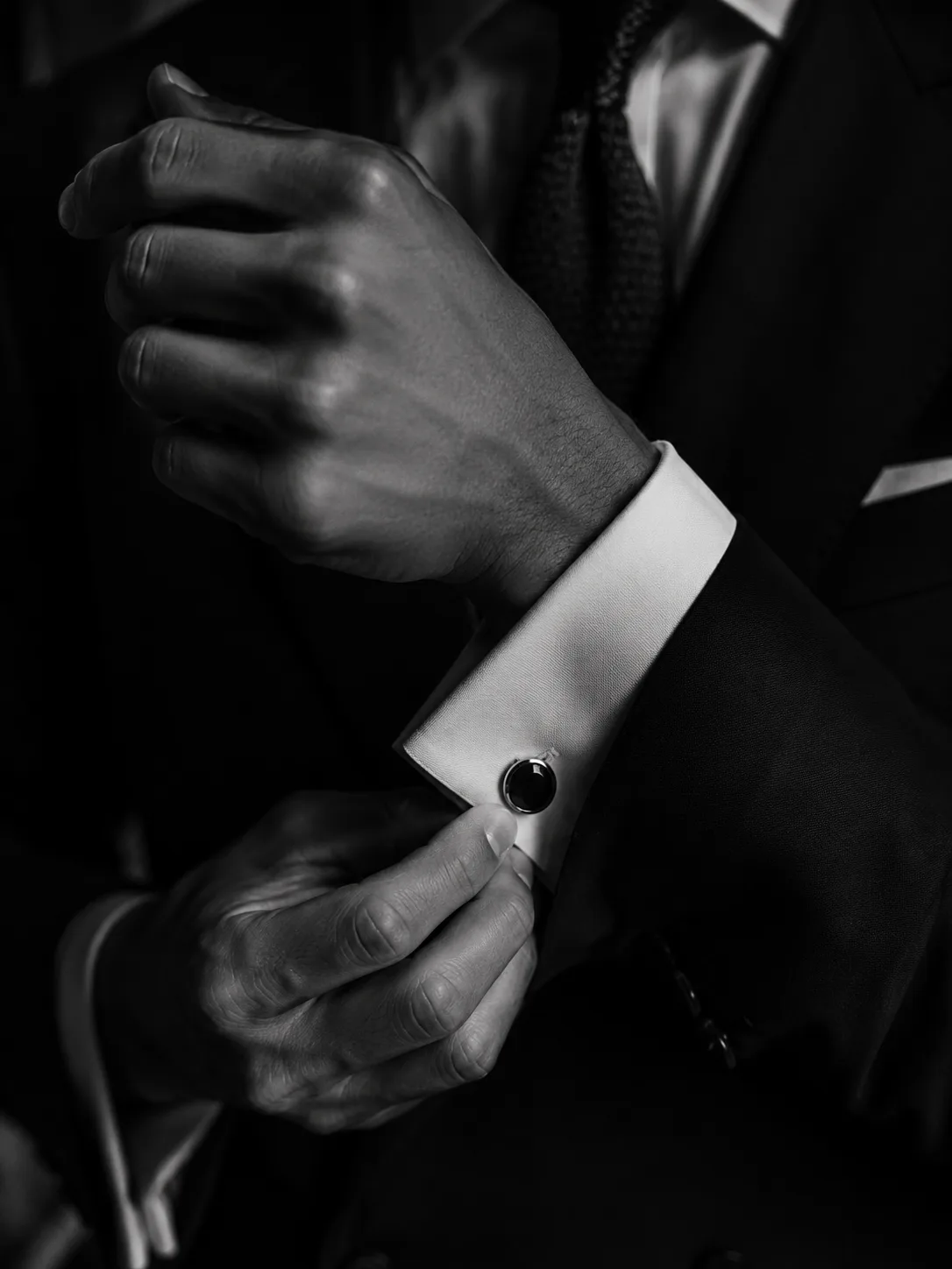 Discreet male companion fastening a cufflink before a Mayfair engagement.